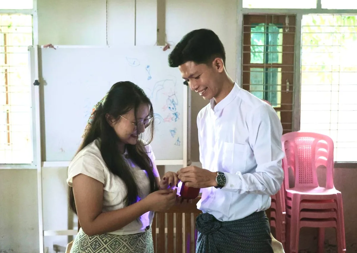 Htet placing the ring on Gloria's finger