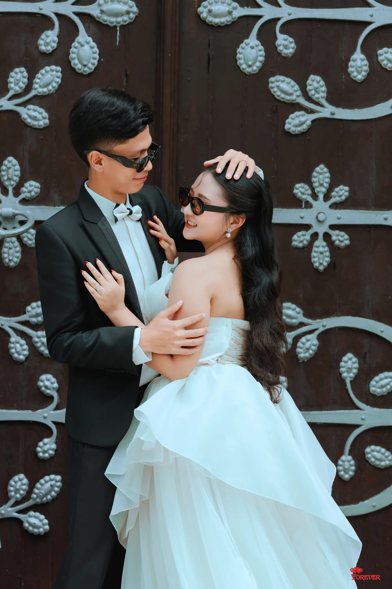 Htet and Gloria in front of a carved church door